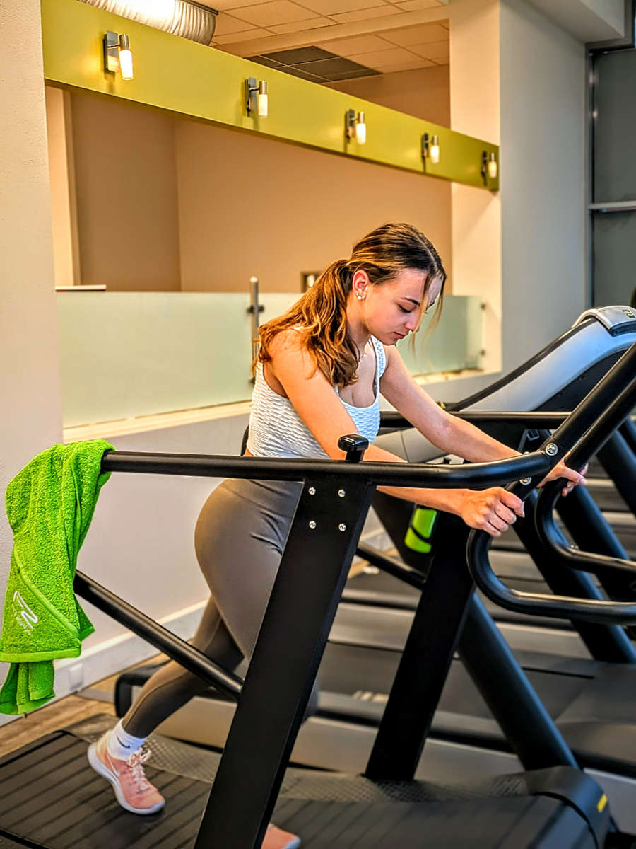 Junge Frau trainiert am Laufband
